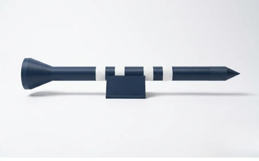 The Big Tee resting horizontally in the included desk stand, in Dark Blue with Ivory White rings